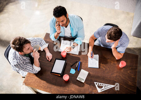 Vista aerea del concentrato di giovani uomini al lavoro sul progetto a small office meeting Foto Stock