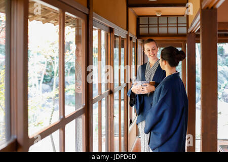 La donna caucasica indossare uno yukata Giapponesi con amico al ryokan tradizionale, Tokyo, Giappone Foto Stock