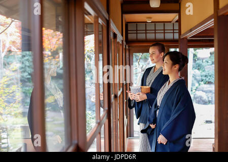 La donna caucasica indossare uno yukata Giapponesi con amico al ryokan tradizionale, Tokyo, Giappone Foto Stock