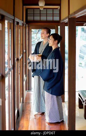 La donna caucasica indossare uno yukata Giapponesi con amico al ryokan tradizionale, Tokyo, Giappone Foto Stock