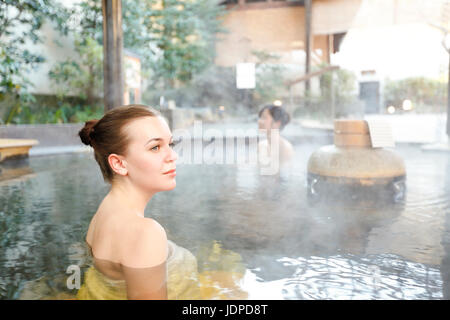 La donna caucasica con amico giapponese di balneazione tradizionale a primavera calda, Tokyo, Giappone Foto Stock