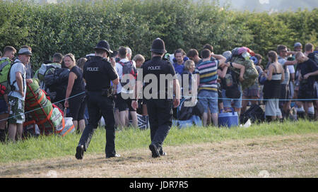 La polizia guarda oltre festivalgoers arrivando per il festival di Glastonbury presso l'azienda agricola degna in Pilton, Somerset. Foto Stock