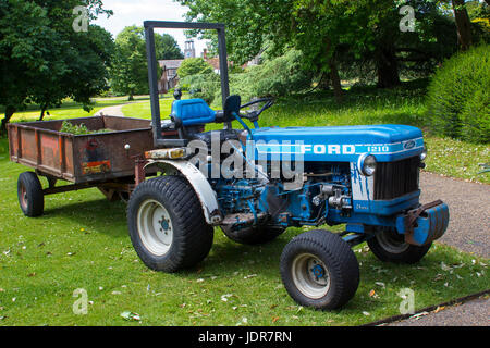 Un vecchio ma ben mantenute Ford il trattore e il rimorchio della scatola in uso quotidiano nella West Dean Estate Gardens nel West Sussex, in Inghilterra Foto Stock