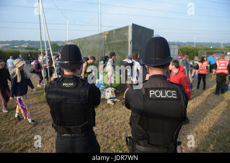 La polizia guarda oltre festivalgoers arrivando per il festival di Glastonbury presso l'azienda agricola degna in Pilton, Somerset. Foto Stock