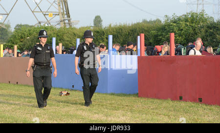 La polizia guarda oltre le persone che arrivano per il festival di Glastonbury presso l'azienda agricola degna in Pilton, Somerset. Foto Stock