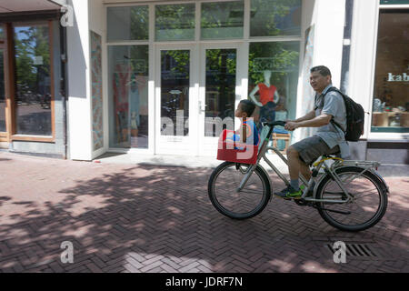 Leeuwarden, Paesi Bassi, 11 giugno 2017: padre trasporta il suo figlio in cassa in bicicletta nelle strade IN LEEUWARDEN NEI PAESI BASSI Foto Stock