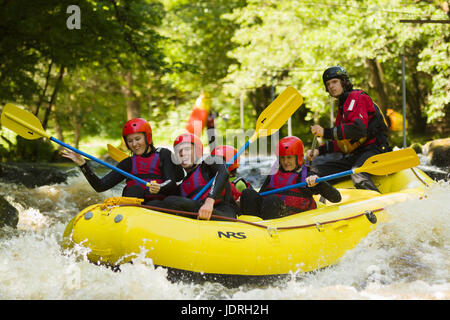 Acqua bianco rafters Shooting the Rapids presso il National White Water centro sul fiume Tryweryn vicino a Bala Foto Stock