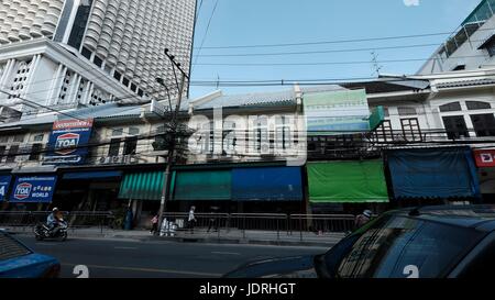 Gli edifici di cavi elettrici vibranti diurno urbano persone Charoen Krung Road Sathon Bangkok in Thailandia Foto Stock
