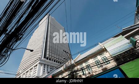 Gli edifici di cavi elettrici vibranti diurno urbano persone Charoen Krung Road Sathon Bangkok in Thailandia Foto Stock