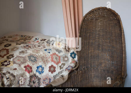 Letto matrimoniale con culla in vimini in shipwright's cottage a scudo del disco Foto Stock