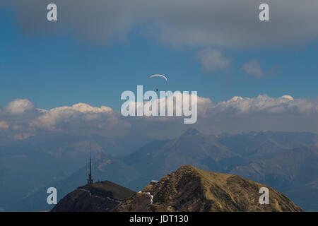 Un parapendio in montagna con cielo blu e nuvole con il sole Foto Stock
