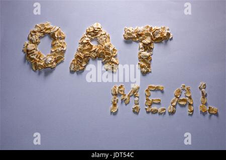 Mangiare sano - Le parole di farina di avena scritto con fiocchi di avena su sfondo bianco Foto Stock