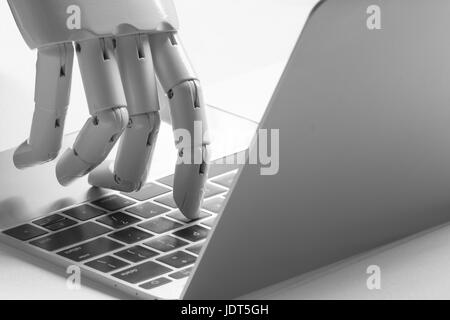 Chatbot , intelligenza artificiale , robo advisor , concezione robotica. Dito di Robot punto a pulsante per laptop. Foto Stock