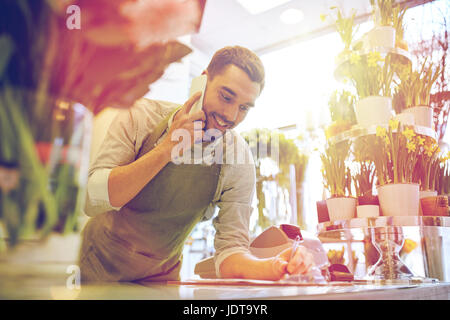 Uomo con lo smartphone rendendo note al negozio di fiori Foto Stock