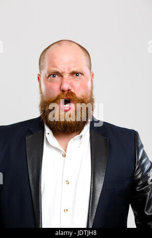 Ritratto di urlando uomo con lo zenzero barba di svuotare lo sfondo grigio Foto Stock
