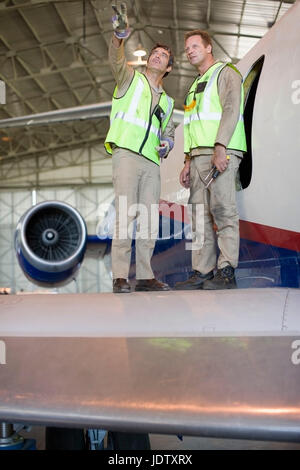 Lavoratori di aeromobili parlando in aereo Foto Stock