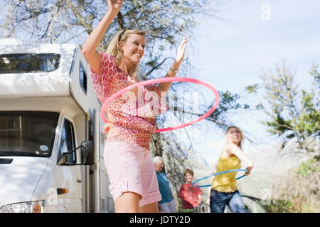 La famiglia tramite hula hoops con RV Foto Stock