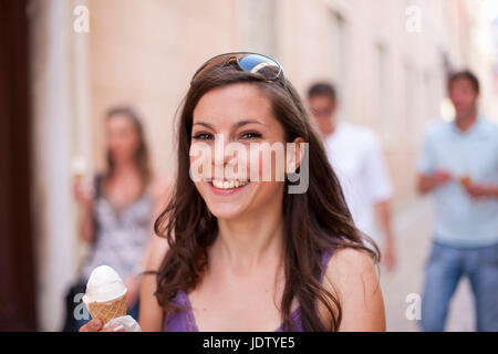 Donna sorridente con cono gelato Foto Stock
