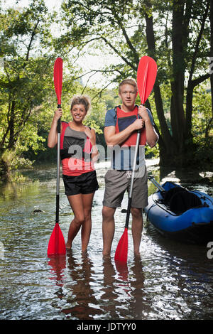 Giovane Azienda kayak pagaie in creek Foto Stock