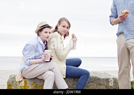 Gli amici di fare colazione in spiaggia Foto Stock