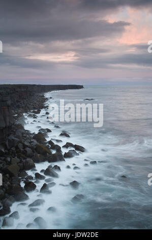 Il lavaggio delle onde sulla costa rocciosa Foto Stock