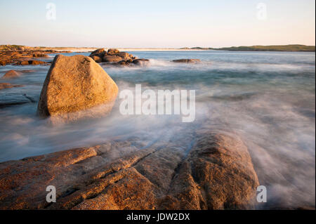 Lavaggio onde sulla spiaggia rocciosa Foto Stock