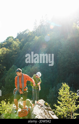 Due arrampicatori in piedi sulle rocce in presenza di luce solare, Chamonix Haute Savoie, Francia Foto Stock