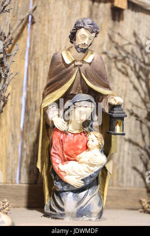 Presepe con la Santa Famiglia e di San Giuseppe che tiene una lanterna illuminata Foto Stock
