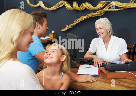 Hotel Receptionist aiutare la famiglia per Check In Foto Stock