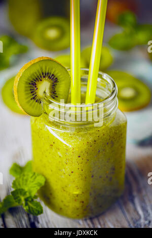 Mescolate fresco verde frullato di frutta in un barattolo di vetro con paglia Foto Stock