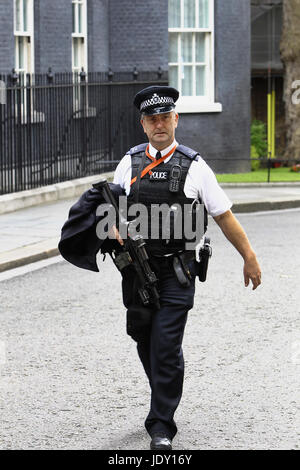 Legge & Ordine, funzionario di polizia che trasportano armi da fuoco a Downing Street, Westminster, Londra, Inghilterra. Foto Stock