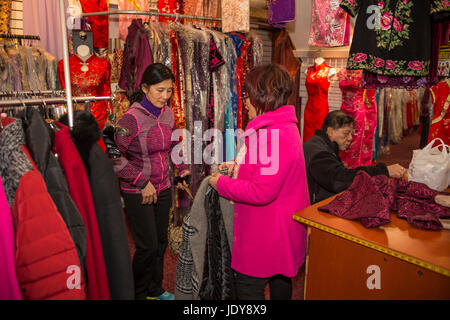 Cinese-donna americana, salesclerk, vendita camicia in vietnamita-donna americana, negozio di abbigliamento, Stockton Street, Chinatown di San Francisco, California Foto Stock