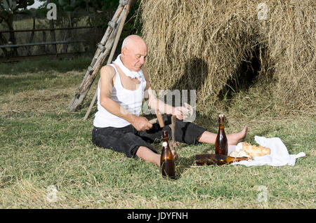 Senior uomo rurale la sua affilatura falce per falciare l'erba Foto stock -  Alamy