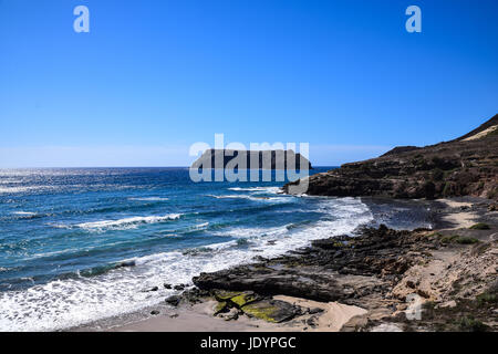 Guardando oltre la piccola insenatura di Calhau da Serra de Fora con Ilheu de Cima all'orizzonte di Porto Santo e di Madeira Foto Stock