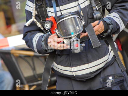 Chiudere fino a firefighter uomo con ossigeno o gas mask nelle sue mani Foto Stock