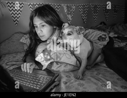 Bambino e cane pagando anttention guardare i video nel computer.la posa Foto Stock