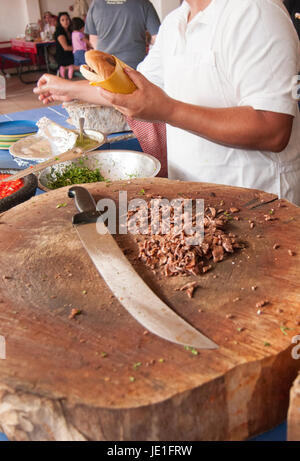 Taquero preparare carne asada TORTA, da un taco stand situato in Rosarito Baja California. Messico. Foto Stock