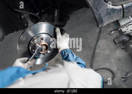 Autofficine mani sostituire i freni in garage. Foto Stock