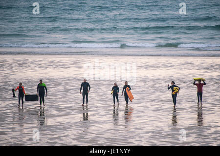 La gente che camminava sul Fistral Beach dopo un surf esercitazione di soccorso. Foto Stock