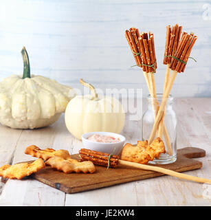 Divertimento in casa rustico streghe Halloween scopa antipasti a base di grissini e salatini servita su una tavola di legno con un gustoso tuffo e bat biscotti Foto Stock