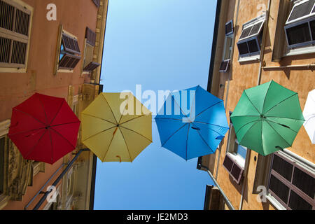 Gli ombrelli di diversi colori su strada con il blu del cielo come sfondo Foto Stock