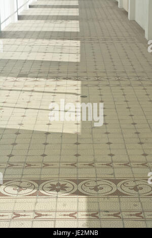 Un lungo corridoio con pavimenti di ceramica Foto Stock