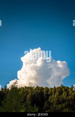 Solitaria nuvola bianca sulla parte superiore della collina Foto Stock