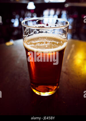 Vintage cercando pinta di inglese bitter ale in un pub Foto Stock