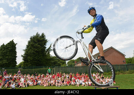 Danny maggiordomo del Extreme Mountain Bike Show di eseguire uno stunt per i bambini di una scuola. Foto Stock