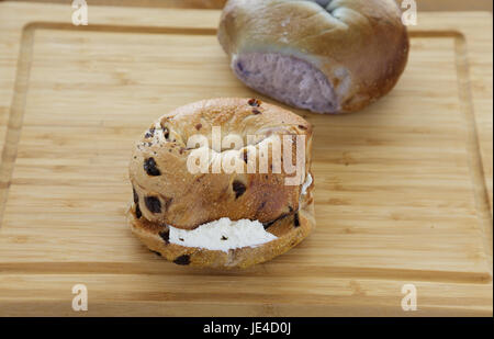 Due bagel sul bordo di taglio Foto Stock