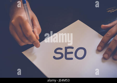 Seo,l'ottimizzazione per i motori di ricerca, uomo d affari la scrittura su carta bianca in ufficio Foto Stock
