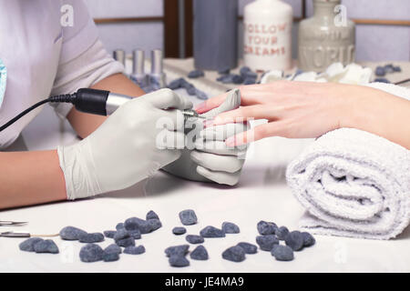 Closeup dito unghie manicure da specialista in un salone di bellezza. Foto Stock
