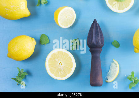 Limone fresco agrumi con foglie di menta e citrus alesatore su blu bakground Foto Stock