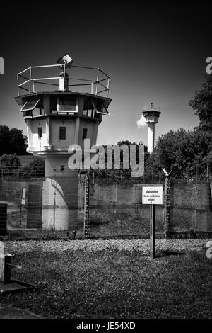 25 anni fa la rivoluzione pacifica ha strappato il muro. Prima del 9 novembre 1989 la cortina di ferro era una zona di morte in Germania: 245 persone, che volevano fuggire dalla Germania orientale, dove sono state uccise nel tentativo di attraversare questo confine disumano. MoedLareuth, un piccolo villaggio, è stato seperato da questo muro in una parte occidentale e orientale come a Berlino. Per questo motivo è stata chiamata piccola Berlino. Il segno in primo piano è molto cinico:'striscia di protezione.No trespassing!'. Foto Stock